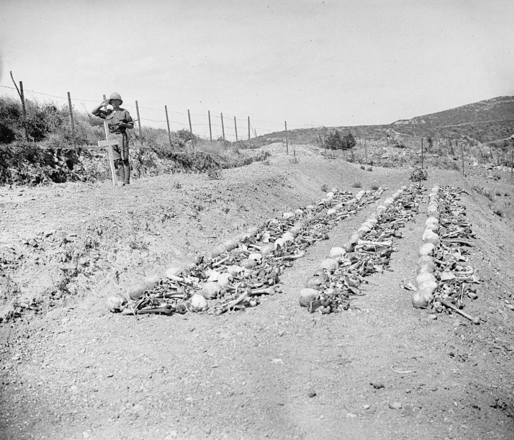 A soldier solutes at a grave prepared for the remains of New Zealand soldiers killed at Chunuk Bair.